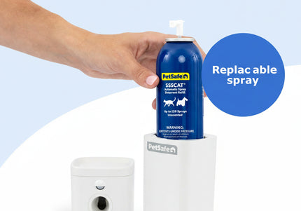 Hand holding a PetSafe spray bottle with a white container on a light blue background